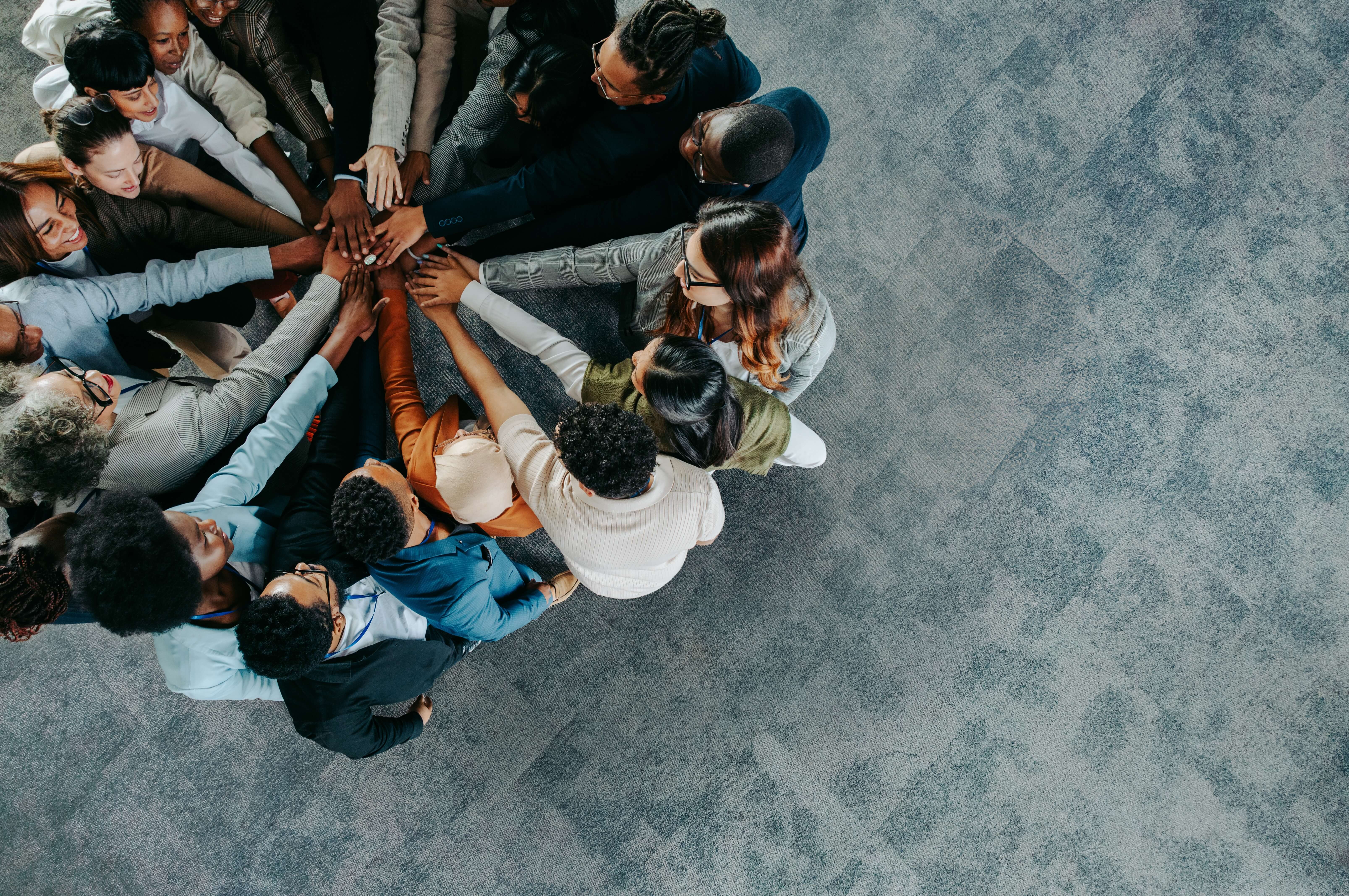 People in a circle, all hands together